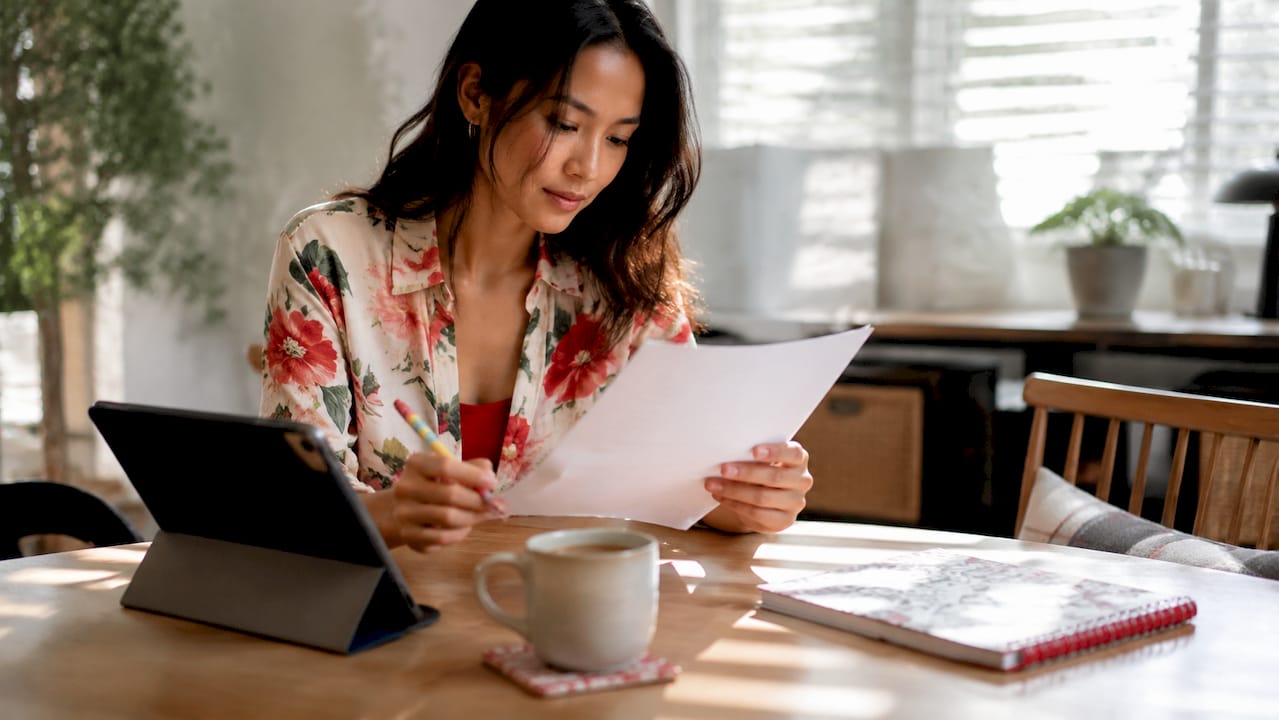 Woman reviewing mortgage pre-approval letter at home