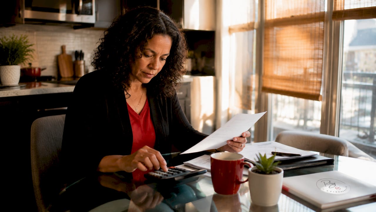 Woman reviewing mortgage documents with calculator