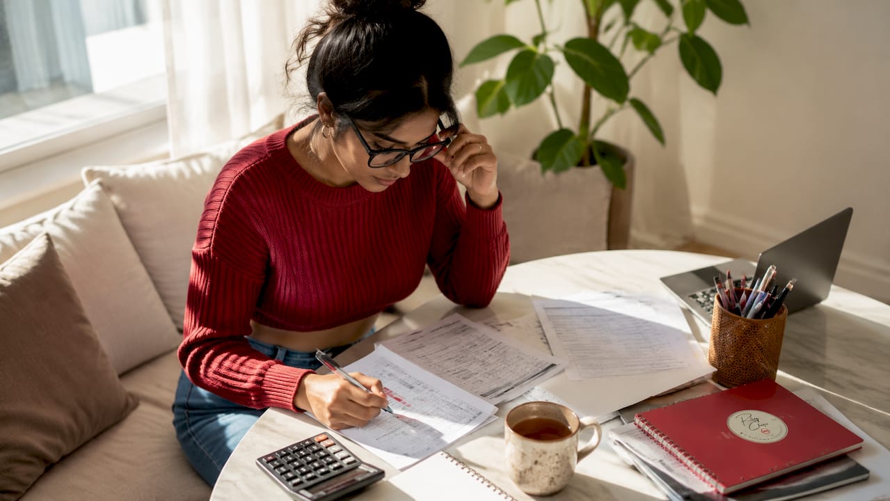 Homebuyer reviewing mortgage documents at kitchen table